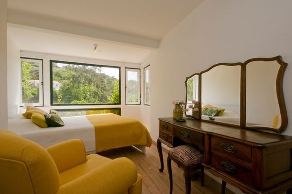 The Yellow Room from the other side, with an antique dresser and mirror beside the window.