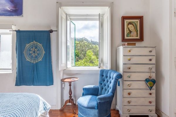 The Blue Room's reading corner: a blue velvet armchair beside the window, with a chest of drawers alongside.