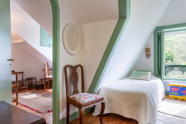 The Twin Room under the eaves, with an embroidered chair and an oval mirror on the sloping wall.