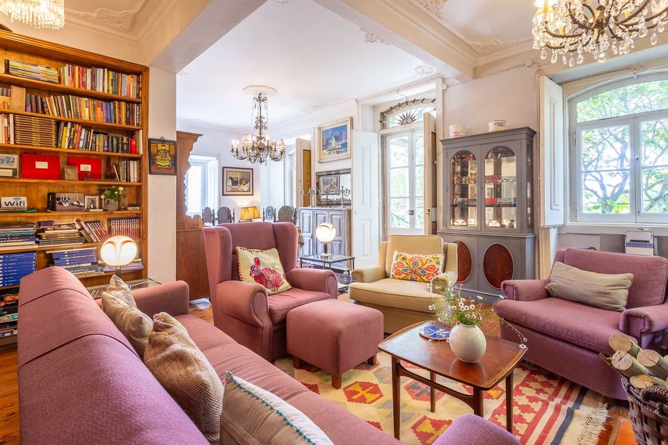A second view of the living room, with tall bookshelves filling the far wall beside the windows.