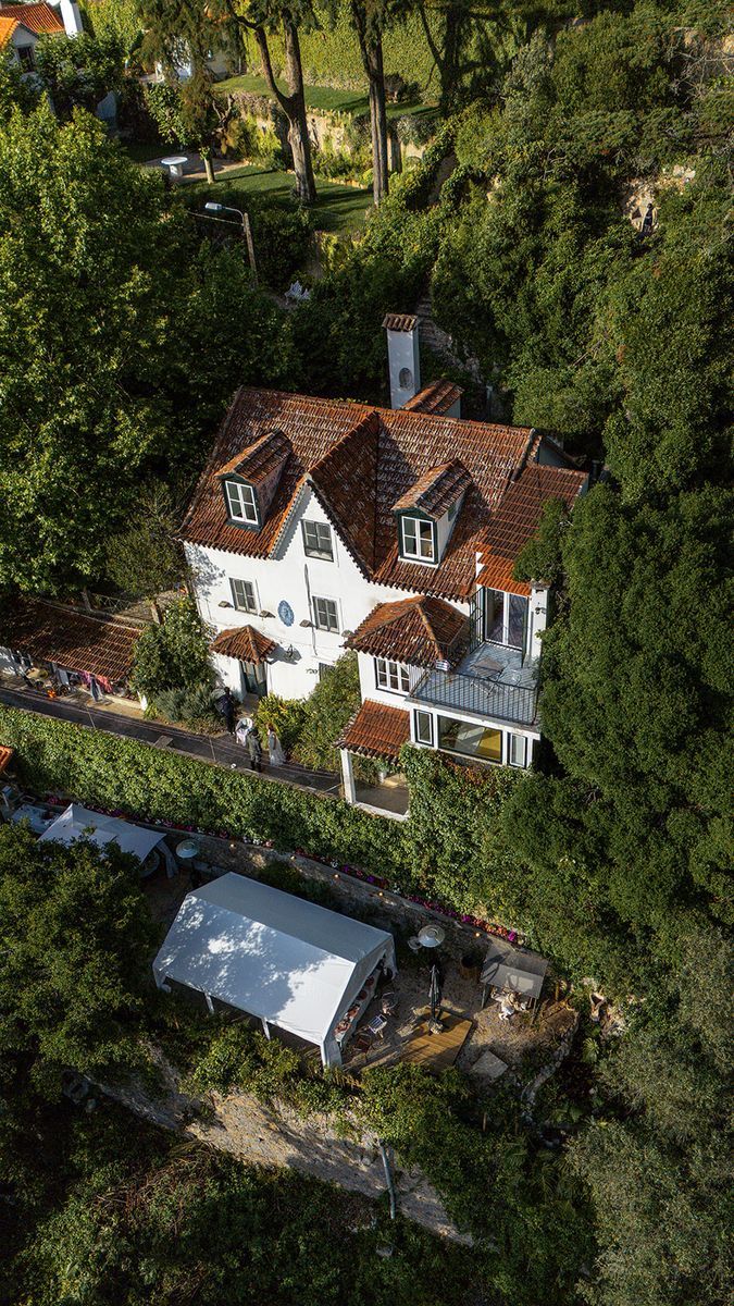 The house from the air, its three floors stepping down the wooded slope, with the marquee pitched in the garden below it.